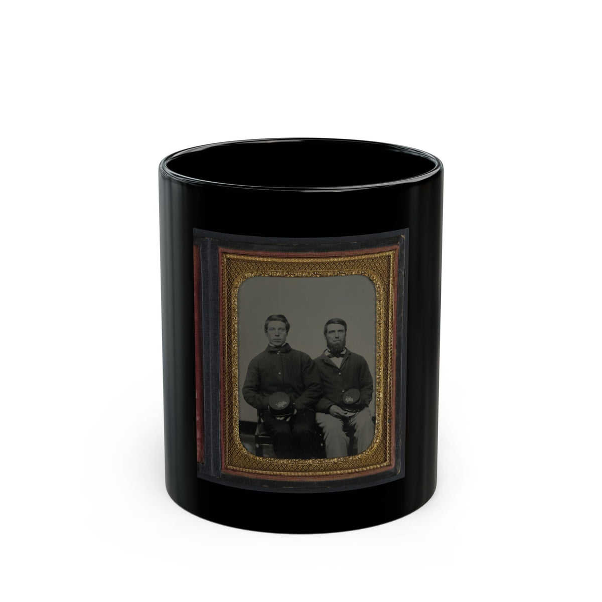 Two seated men in dark jackets holding kepi caps, in a vintage tintype portrait framed in gold diamond-pattern metal.