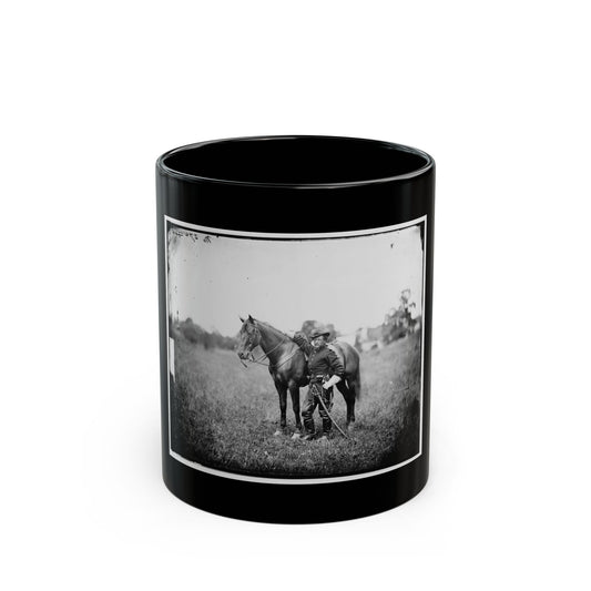Black-and-white historical view of a cavalry officer in white gloves beside a dark horse in an open field.