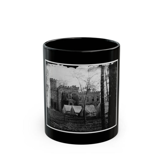 Black and white 19th-century view of a stone castle-like building with canvas tents and bare trees in front.