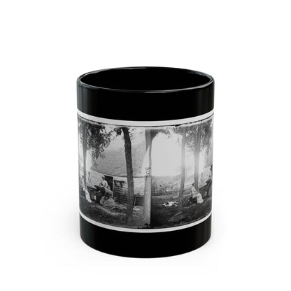 Black and white stereograph of a group of people gathered outside a stone cabin with a shingled roof under tall trees.