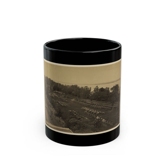 Sepia 19th-century photograph looking down on rows of cannon on carriages across a tree-lined lawn beside a river.