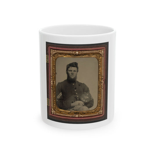 Sepia portrait of a bearded young soldier resting his hands on a kepi with an eagle badge, in an ornate gilt case.