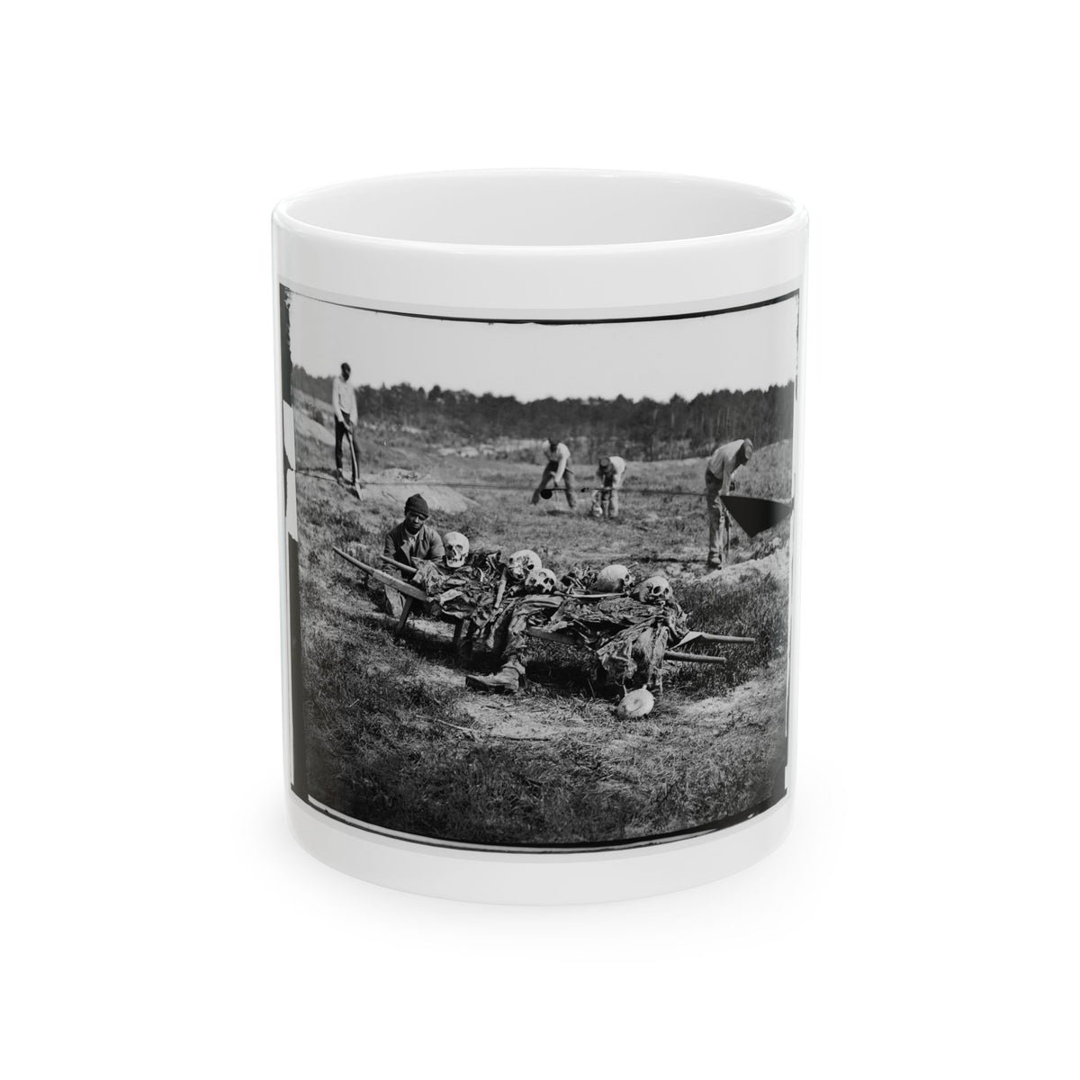 Black and white 1860s print of skulls and remains on a wooden litter in a grassy field, with men digging nearby.
