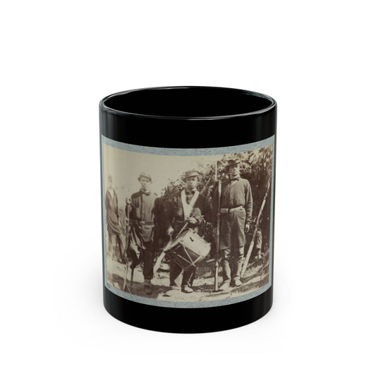 Sepia print showing three soldiers standing outdoors, one holding a snare drum, with rifles beside them.