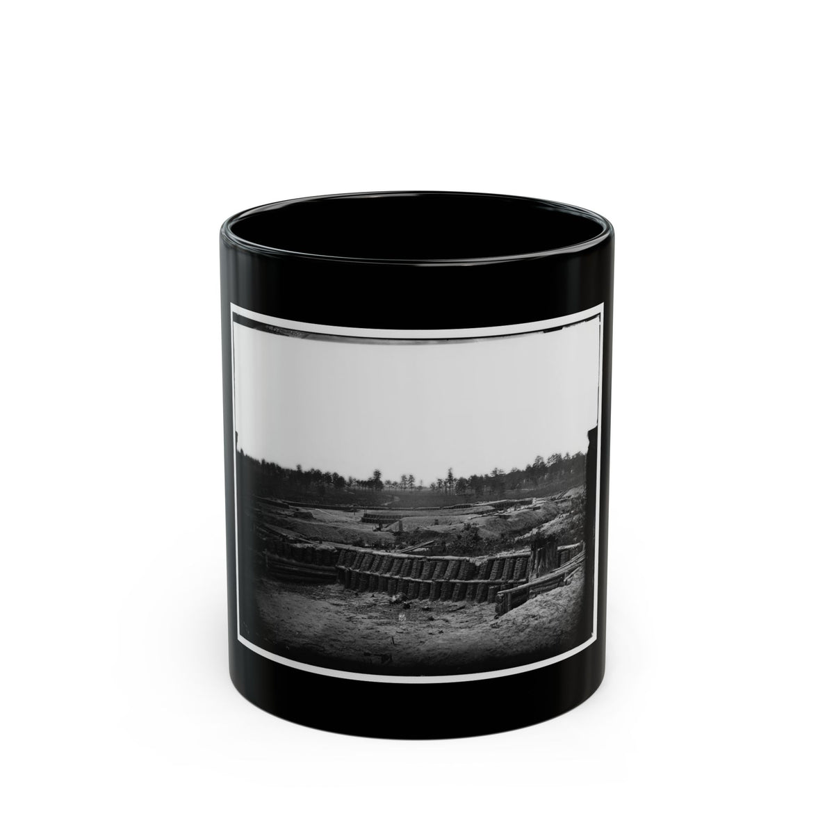 Black and white view of earthworks built from woven baskets and log walls along trench lines on an open field.