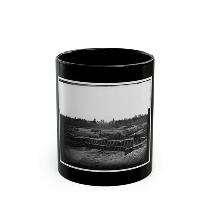 Black and white view of earthworks built from woven baskets and log walls along trench lines on an open field.