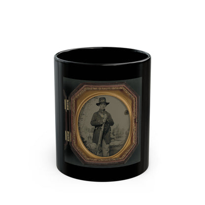 Tintype of a soldier in a bugle-emblem hat holding a rifle before a painted camp scene, in an octagonal gilt case.
