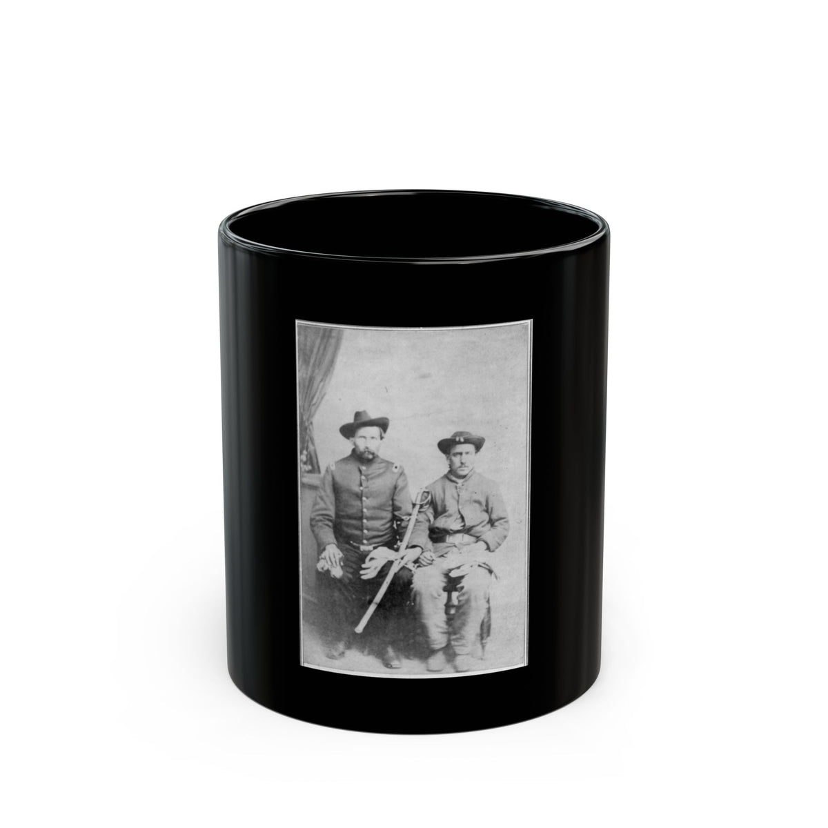 Black and white studio portrait of two seated men in wide-brimmed hats and military-style coats, one holding a sword.
