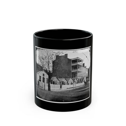 Black and white 1860s view of a multi-storey brick building with wooden balconies and a horse-drawn carriage.