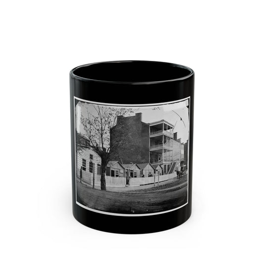 Black and white 1860s view of a multi-storey brick building with wooden balconies and a horse-drawn carriage.