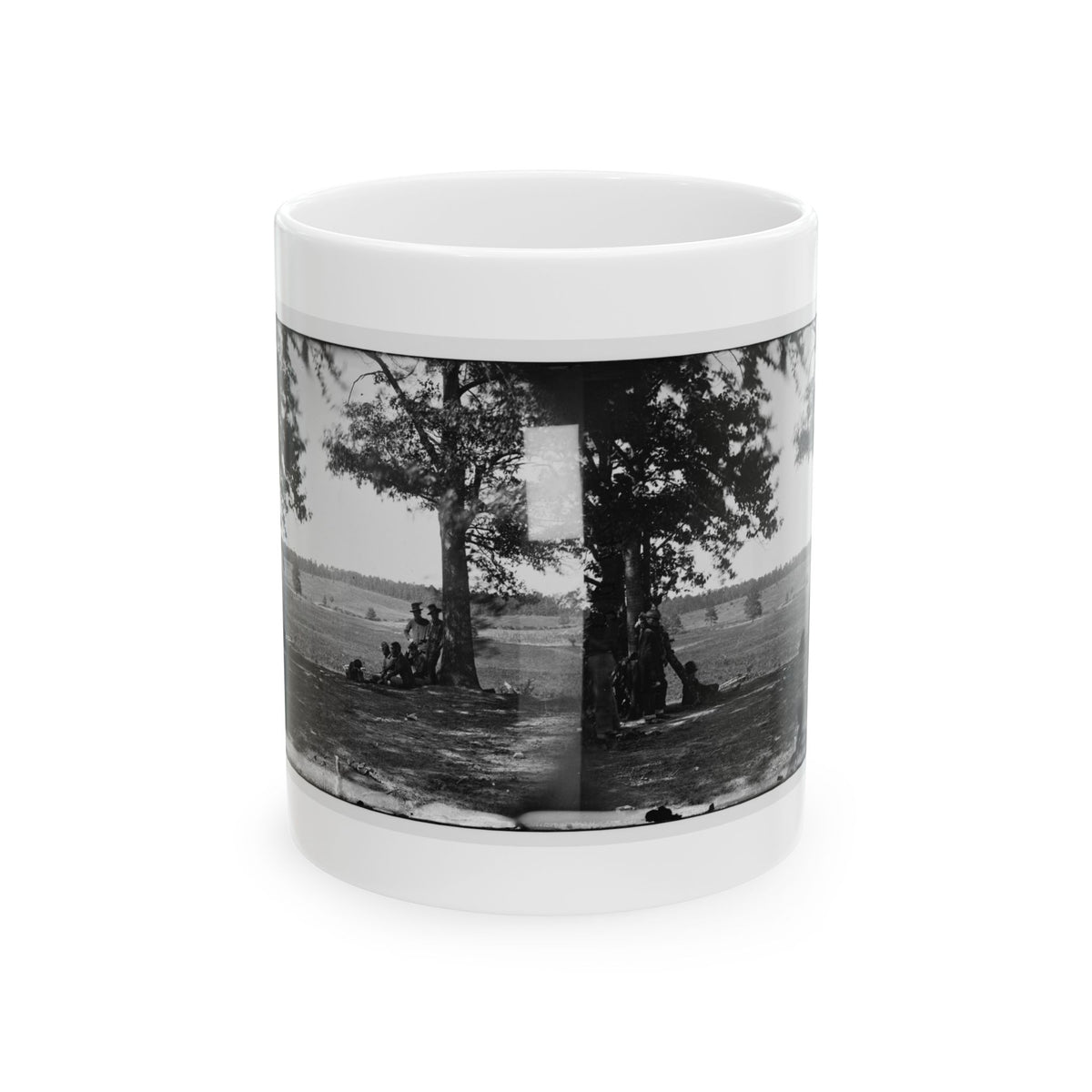 Black and white stereograph of soldiers resting under large trees in an open grassy field, seen as a paired view.