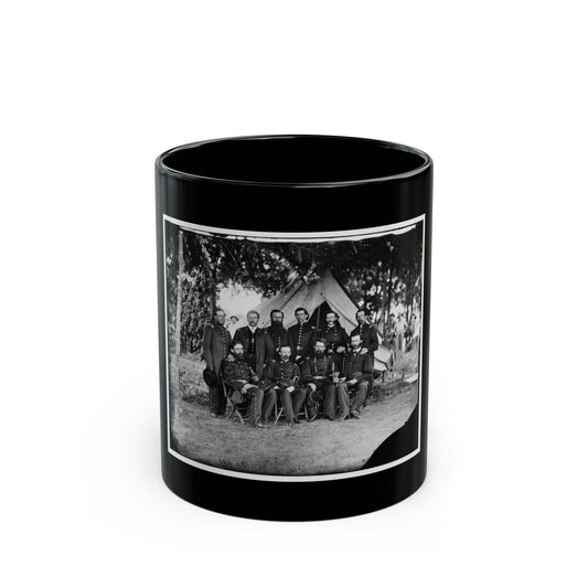 Black and white group portrait of ten uniformed officers in front of a canvas tent beneath trees on grass.