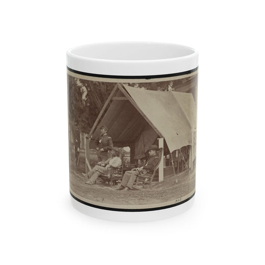 Sepia scene of uniformed officers seated and standing beside a canvas tent in an outdoor encampment.