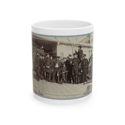 Sepia group scene of about fifteen uniformed naval officers posed on a wooden ship deck beside coiled ropes.