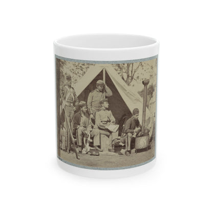 Sepia print showing five soldiers resting around a canvas tent and an iron camp stove, one holding a rifle.