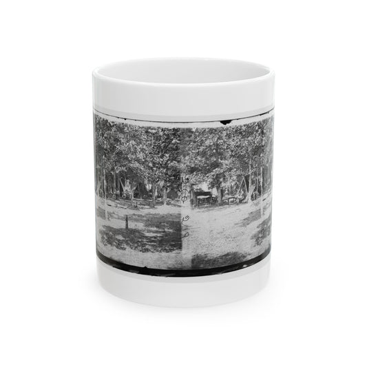 Overexposed black and white stereograph of two matching views of a wooded camp with small tents under a tree canopy.