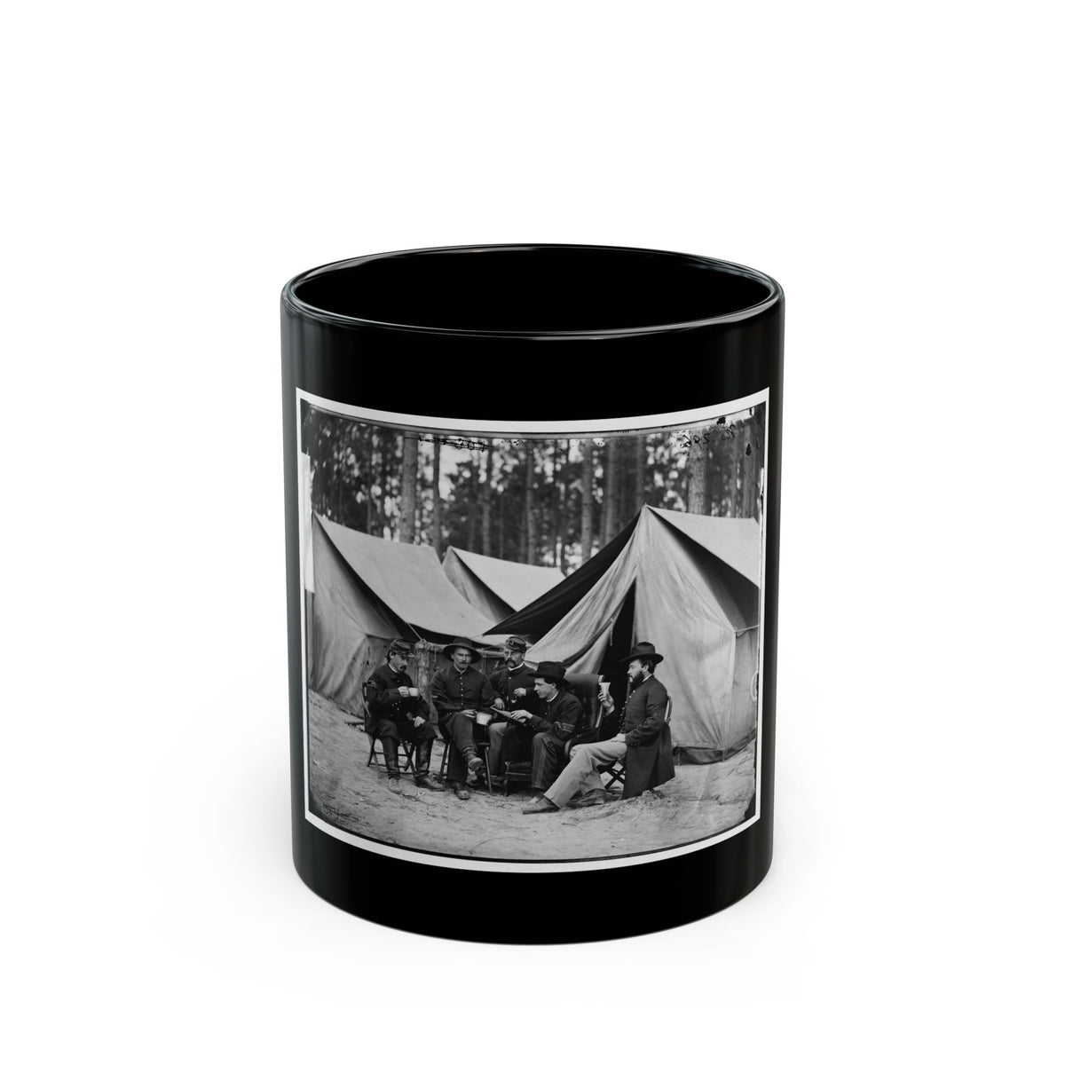 Black-and-white view of five men seated on folding chairs with cups before large canvas tents in a pine grove.
