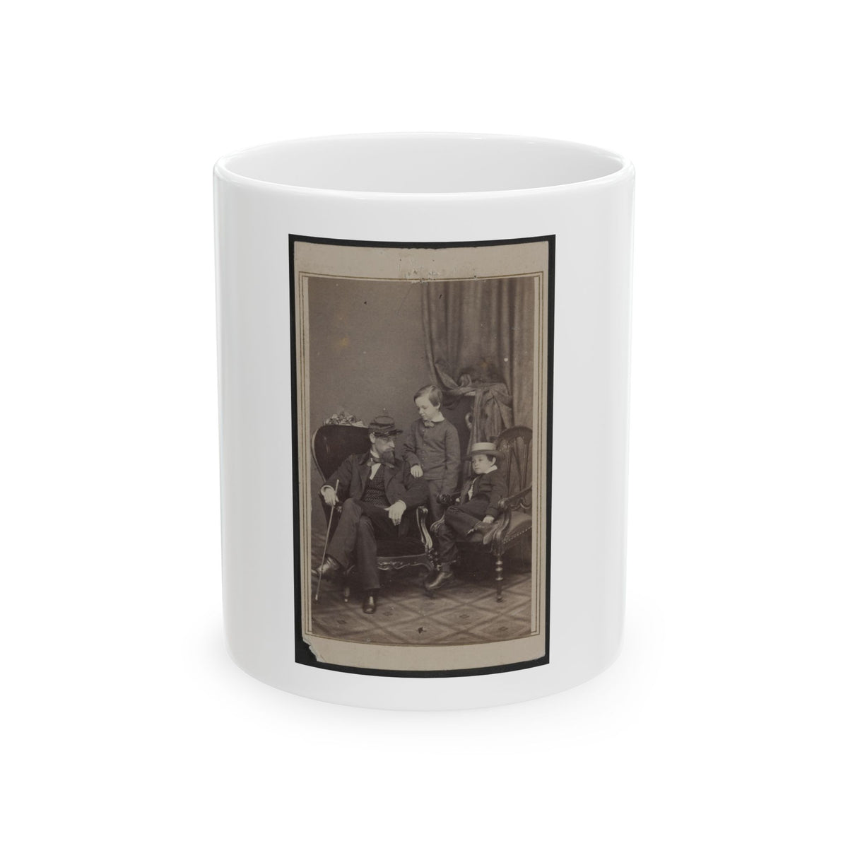 Sepia studio portrait of a bearded man in a kepi seated with two young boys, one wearing a straw boater hat.