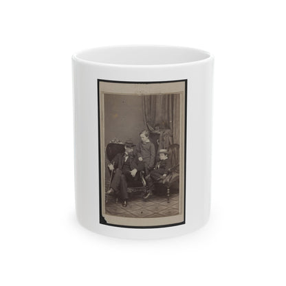 Sepia studio portrait of a bearded man in a kepi seated with two young boys, one wearing a straw boater hat.