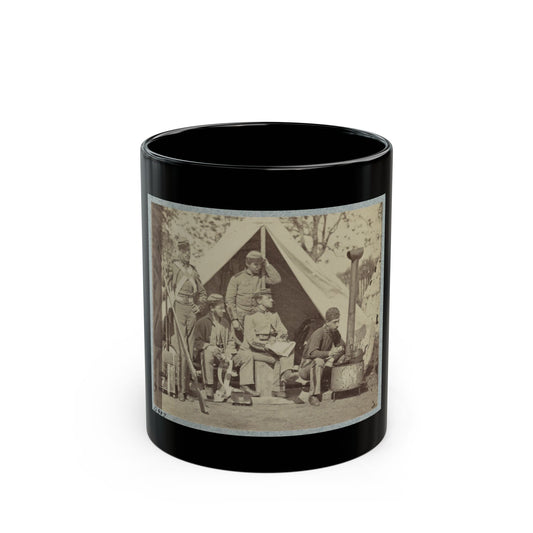 Sepia print showing five soldiers resting around a canvas tent and an iron camp stove, one holding a rifle.