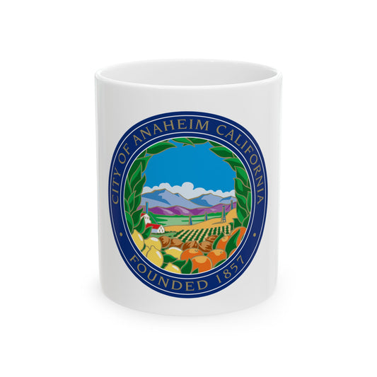 Navy circular seal of Anaheim showing citrus groves, a farmhouse and blue mountains, lettered around its rim.