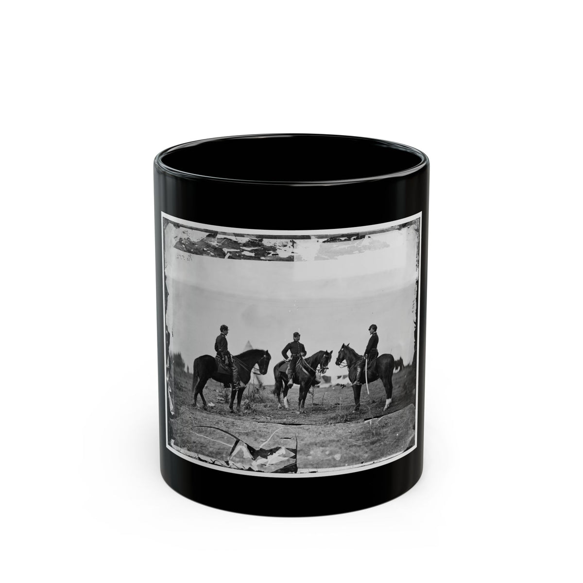 Black and white view of three mounted soldiers on dark horses in an open field under a pale sky.