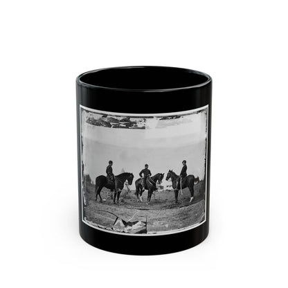 Black and white view of three mounted soldiers on dark horses in an open field under a pale sky.