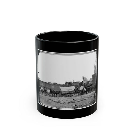 Black and white 1860s view of a canvas-covered wagon marked U.S. Sanitary Commission beside horses and men.