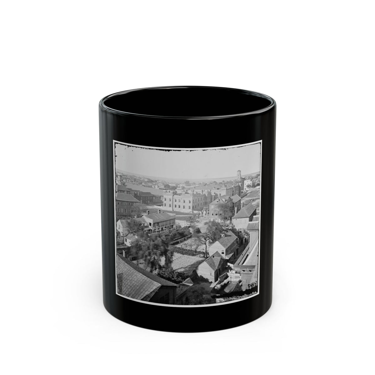 Black-and-white aerial view of a historic city with rooftops, walled gardens and a castellated stone building.