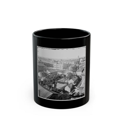 Black-and-white aerial view of a historic city with rooftops, walled gardens and a castellated stone building.