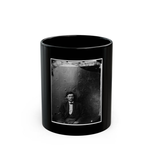 Black and white 1860s studio portrait of a seated man in a dark jacket and bow tie against an arched textured backdrop.