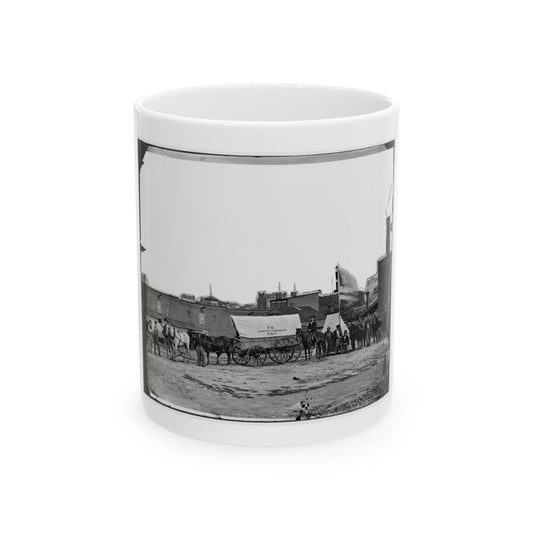 Black and white 1860s view of a canvas-covered wagon marked U.S. Sanitary Commission beside horses and men.
