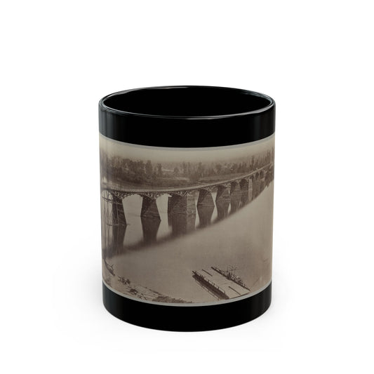 Sepia albumen print of a long timber trestle railway bridge with repeated piers crossing a wide river.