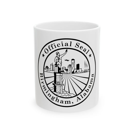 Black and white circular seal with a statue holding a torch above a city skyline and radiating rays.