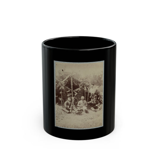 Sepia print showing six 19th-century soldiers with rifles resting in the shade of a leafy shelter.