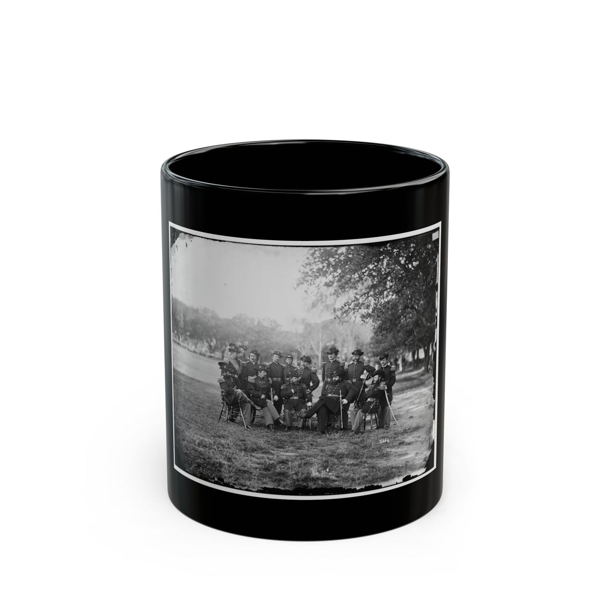 Black and white 1860s group portrait of uniformed officers seated and standing on a grassy lawn under trees.