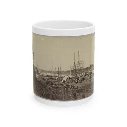 Sepia view of masted sailing ships and a paddle steamboat moored at a riverside landing with wagons on shore.