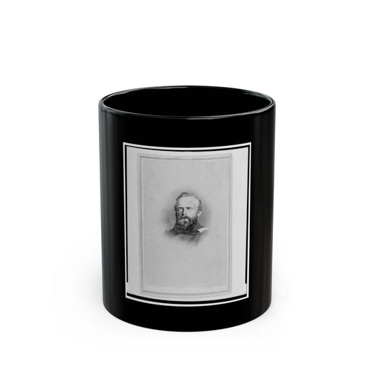Monochrome studio portrait of a bearded man in a dark military coat, set inside a thin rectangular card border.