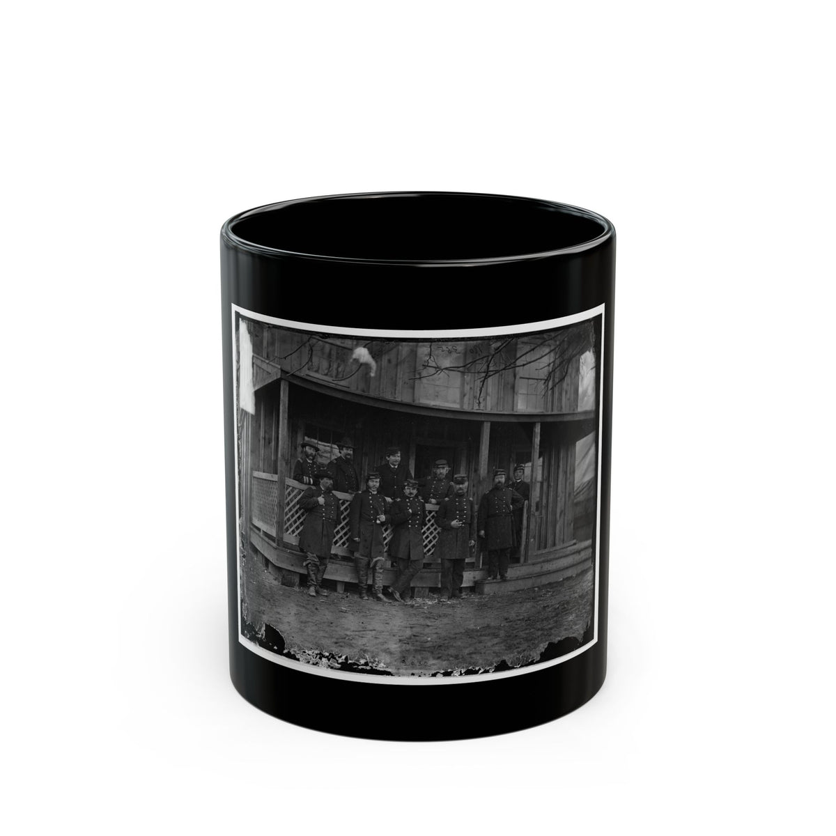 Black-and-white view of ten uniformed officers in caps and coats posed on the porch of a wooden house.
