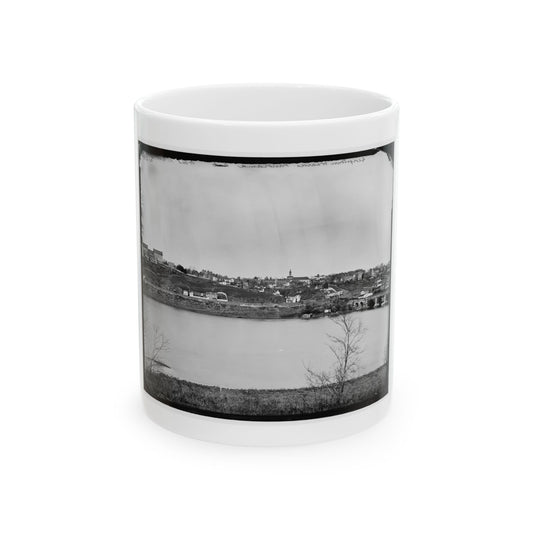 Black and white 19th-century view of a hillside town with a church steeple across a wide river, with a stone bridge.