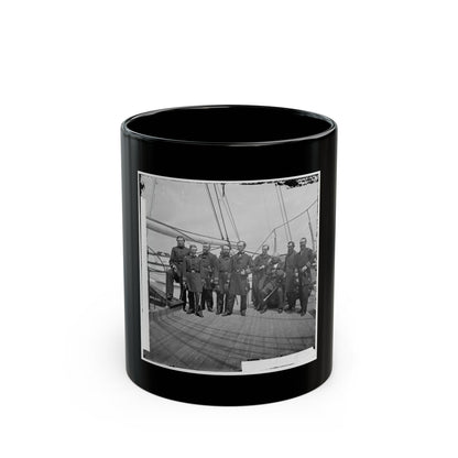 Black and white group portrait of nine uniformed officers, some with swords, on a wooden warship deck.