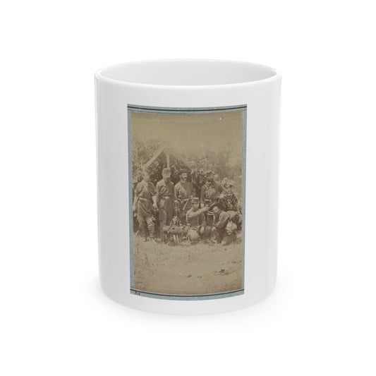 Sepia print showing six soldiers posed outdoors before foliage, some carrying packs, bedrolls and canteens.