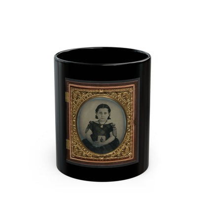 Sepia tintype of a young girl in a dark plaid dress holding a small portrait, inside an oval gilt case.