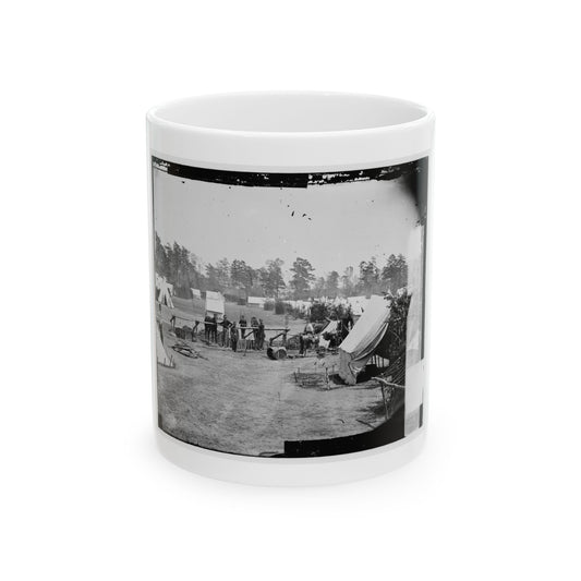 Black-and-white view of a wide army encampment with white canvas tents, tethered horses and soldiers among pines.