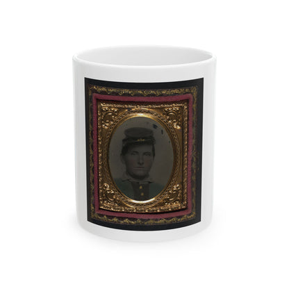 Tintype of a young man in a dark forage cap, shown head and shoulders inside a gilt oval frame with pink velvet.