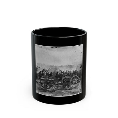 Black and white scene of a field cannon on spoked wheels, with soldiers in a tent camp behind it.